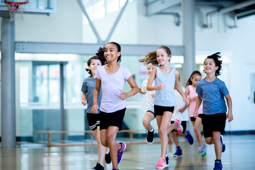 Enfants qui courent dans une salle de sport.